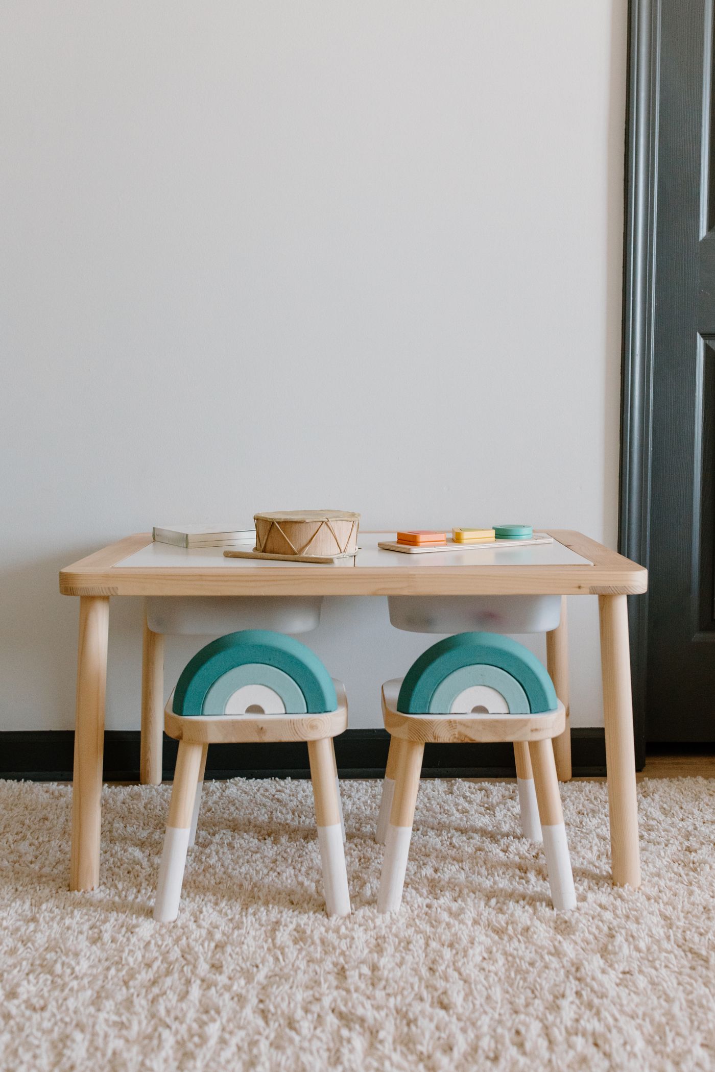 A child-sized table and chairs in a bright play space