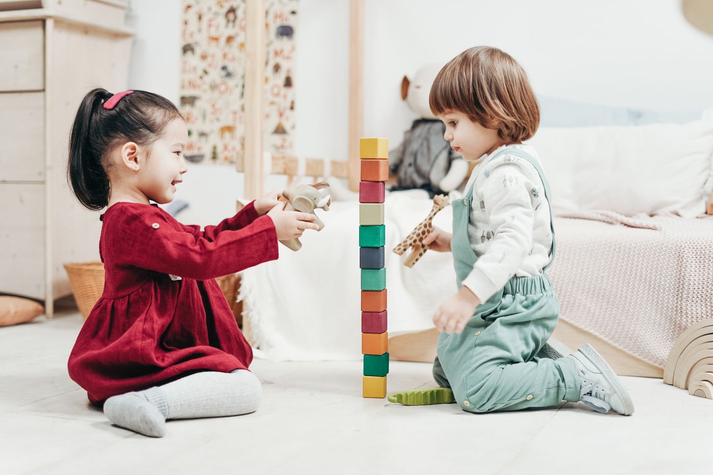 Children playing together with wooden blocks indoors